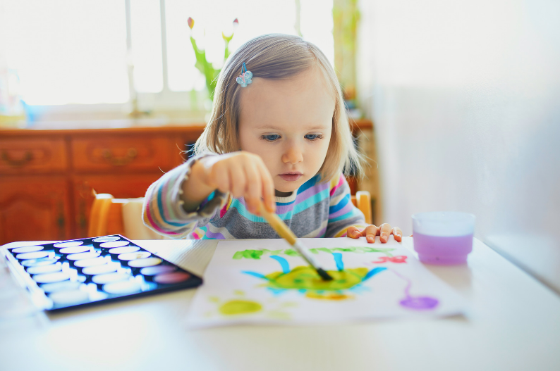 A 2 year old girl painting.