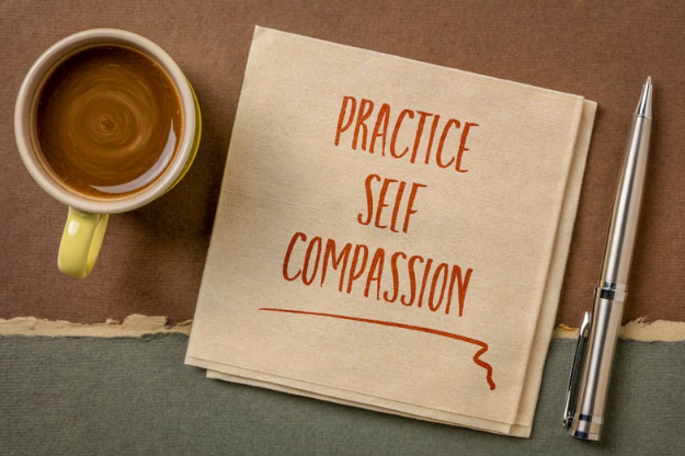 Boek met opschrift 'practice self compassion'.
